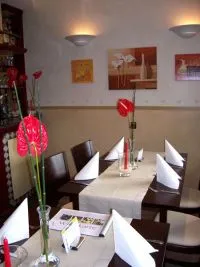 Nahaufnahme eines gedeckten Tisches mit roter Blume im Gourmet