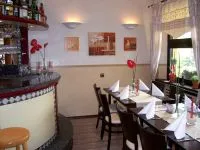 Bar und gedeckte Tische im Gastraum des Gourmet
