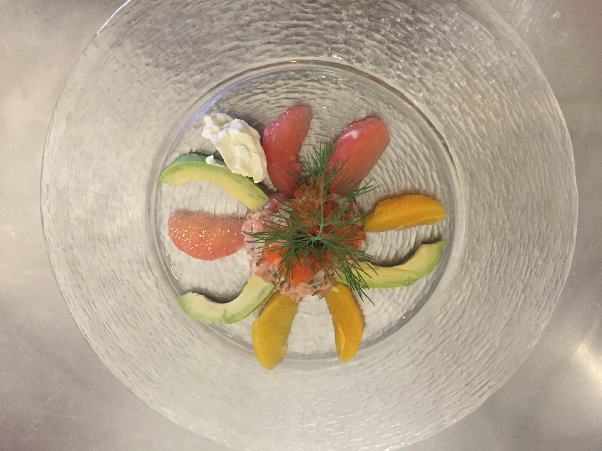Fein angerichtete Vorspeise mit Avocado, Zitrusfrüchten und Kräutern