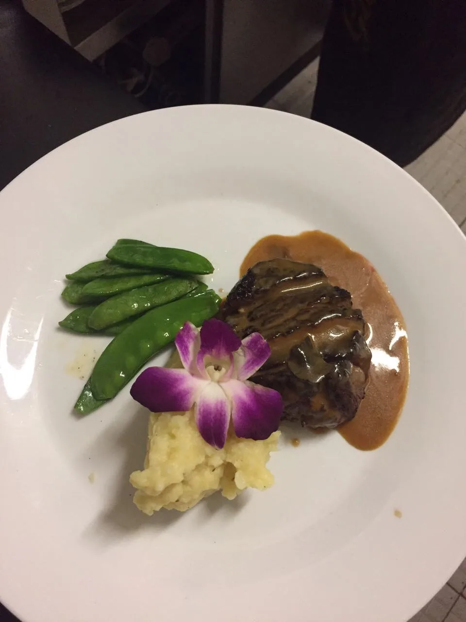 Fleischgericht mit Zuckerschoten, Püree und dunkler Sauce