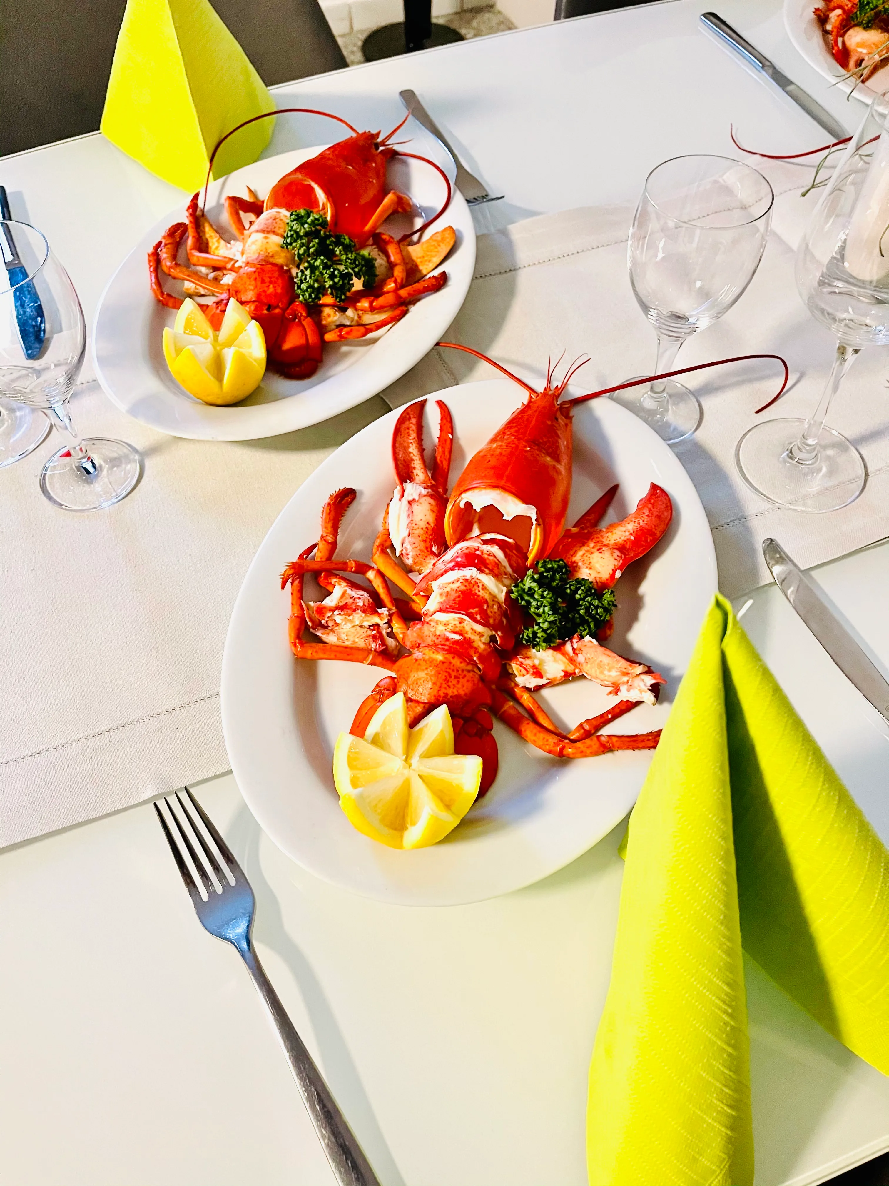 Zwei Hummergerichte auf einer weiß gedeckten Tafel